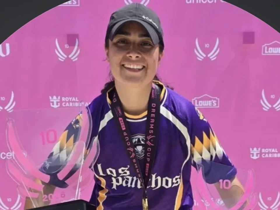 Coach Gabby holding the Dreams Cup champions and MVP trophies